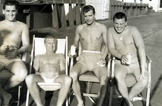 Four junior engineers having a beer on deck